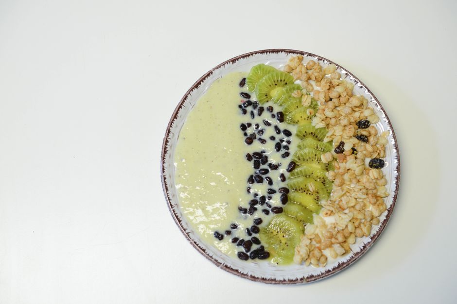 A vibrant kiwi smoothie bowl with nutritious toppings, perfect for a healthy meal.