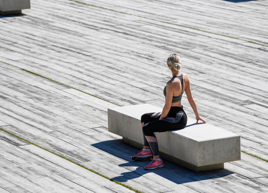 A young woman meditating outdoors on a concrete bench, embracing tranquility and mindfulness.
