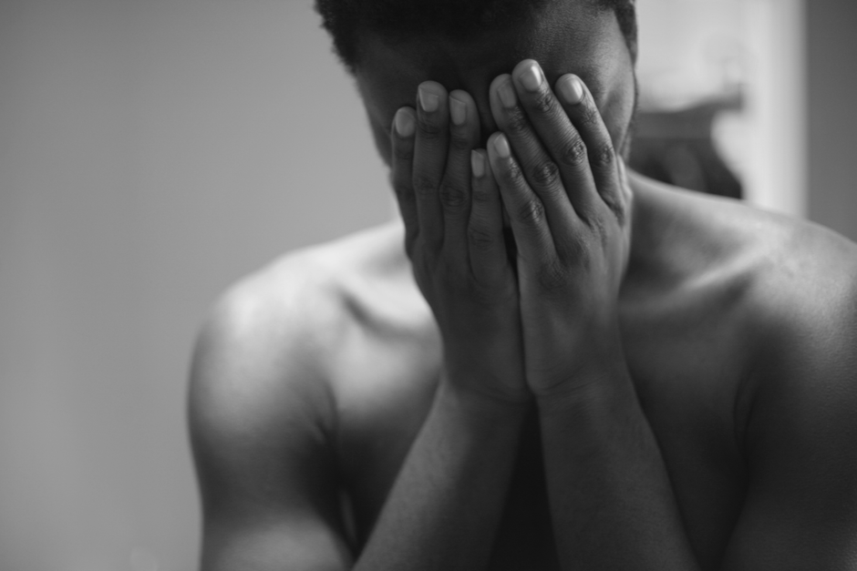 Black and white portrait of a man in distress, conveying deep emotions and vulnerability.