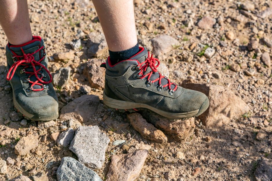 Close-up of hiking boots on rocky ground in Arizona's desert landscape.