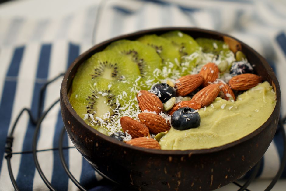 Fresh kiwi and almond smoothie bowl topped with coconut and blueberries. Perfect for a healthy breakfast.