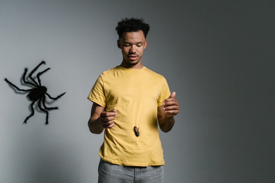 Man confronts phobia with cockroach on shirt; tackling fear and anxiety