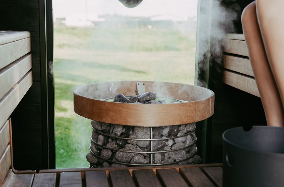 Relax in a beautifully designed sauna featuring steaming stones and wooden benches for a calming experience.