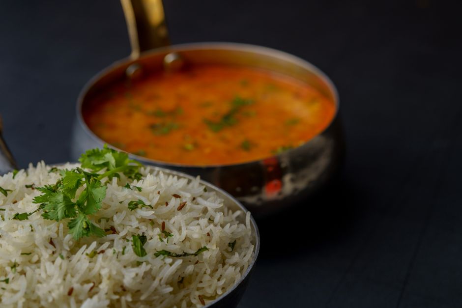 Tasty Indian dal with basmati rice garnished with fresh herbs, perfect for a flavorful meal.