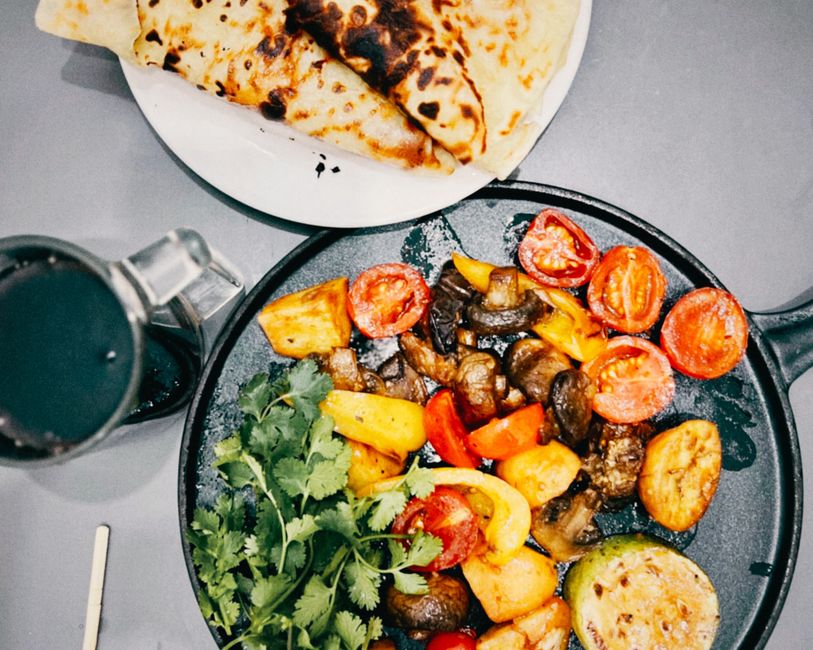 Top view of a colorful grilled vegetable platter with fresh flatbread. Perfect for vibrant food presentations.
