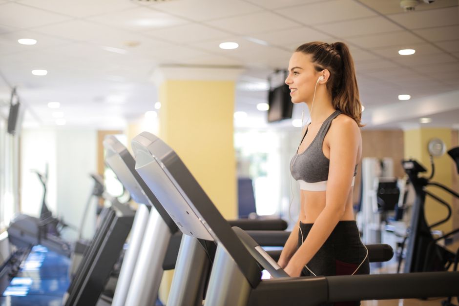 Woman enjoying a workout on a treadmill indoors, promoting fitness and health.