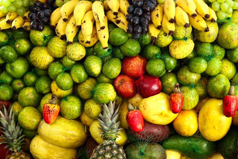 A colorful arrangement of assorted tropical fruits including bananas, apples, pineapples, and citrus.