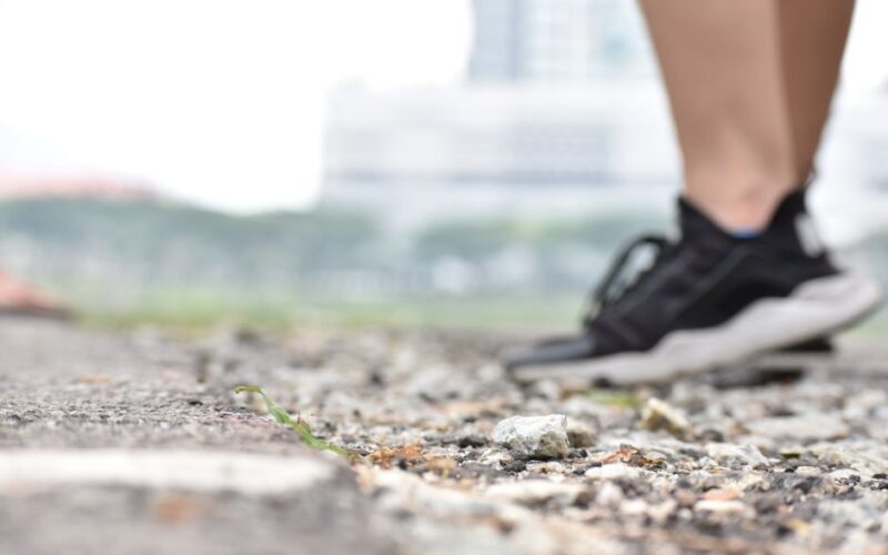 Blurred sneakers on rocky ground, exploring nature outdoors.