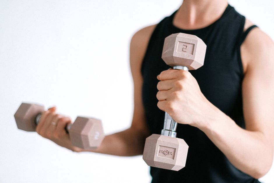 Close-up of a woman lifting dumbbells, focusing on a healthy lifestyle and fitness.