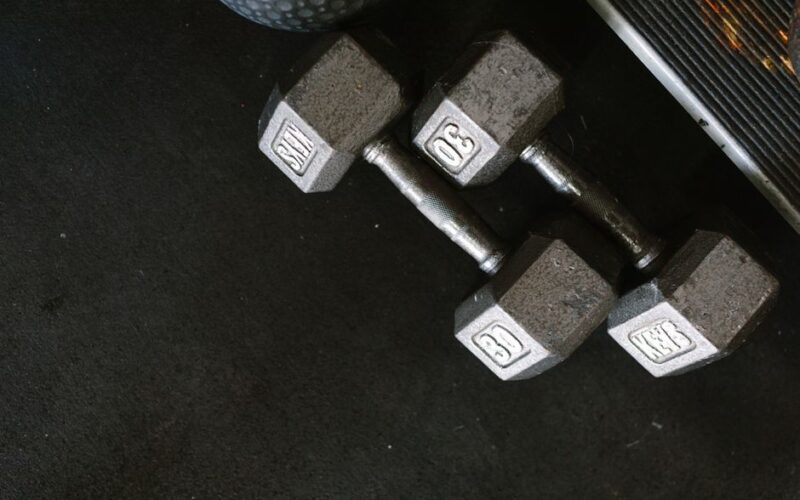Close-up of black dumbbells on a gym floor, perfect for fitness themes.