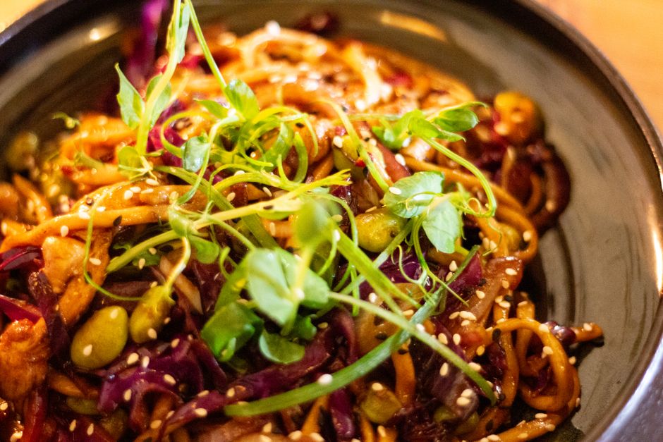Colorful vegan stir-fry noodles with fresh vegetables and sesame seeds.