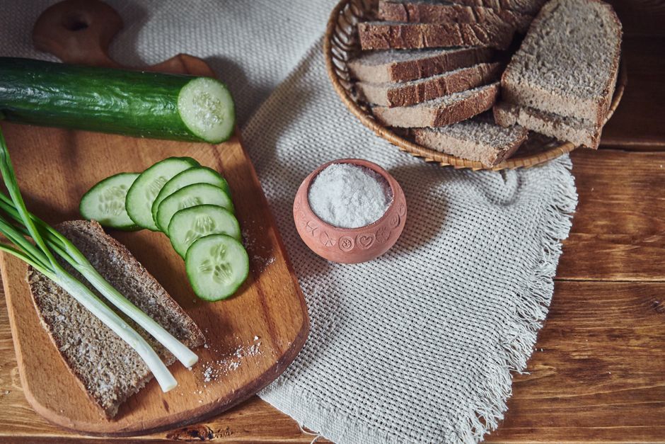 Sliced cucumber and rustic bread on a wooden board, perfect for a healthy snack.