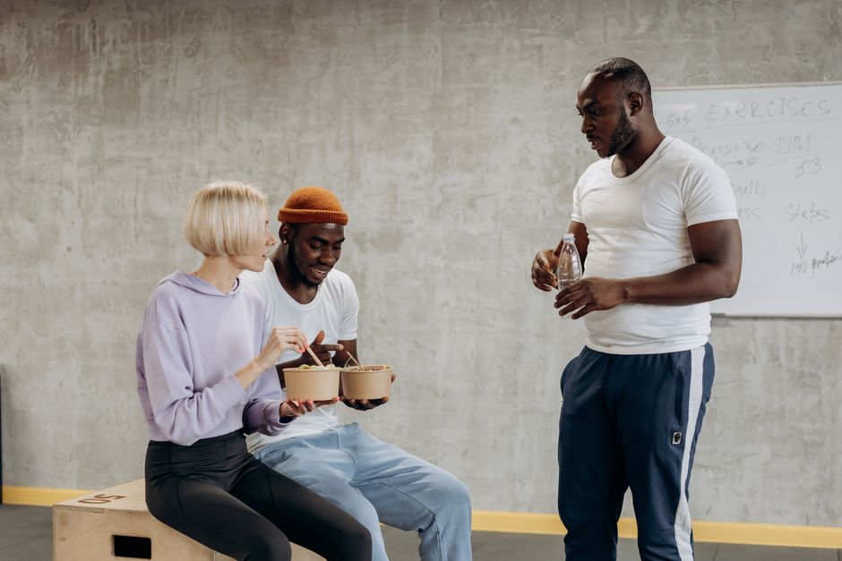 Three adults enjoy a nutritious meal together indoors, embracing a healthy lifestyle.